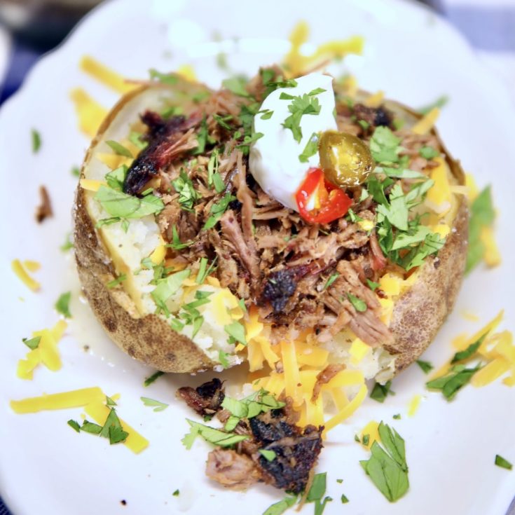 Baked potato topped with cheese, brisket, sour cream.