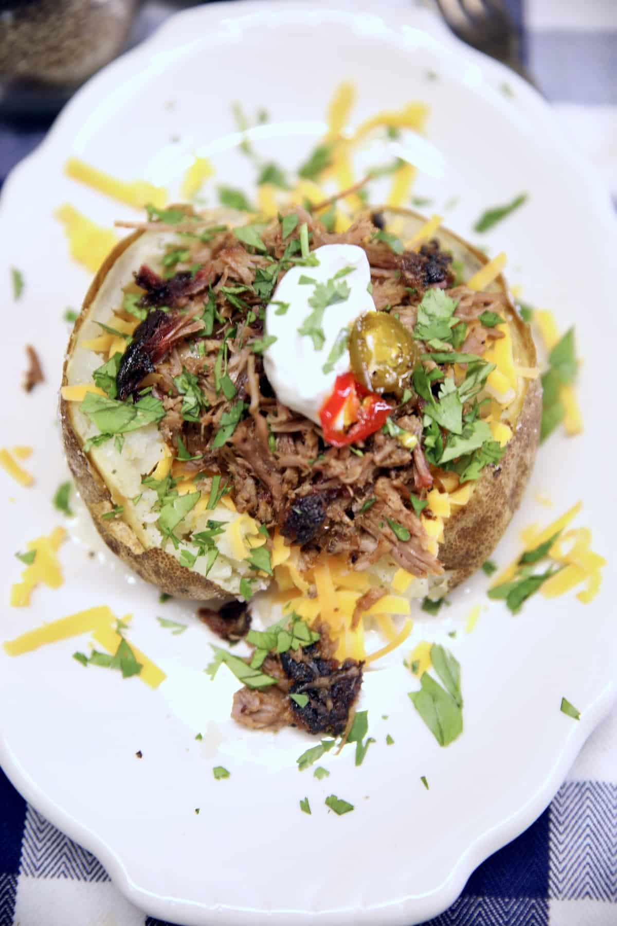 Baked potato topped with cheese, brisket, sour cream.