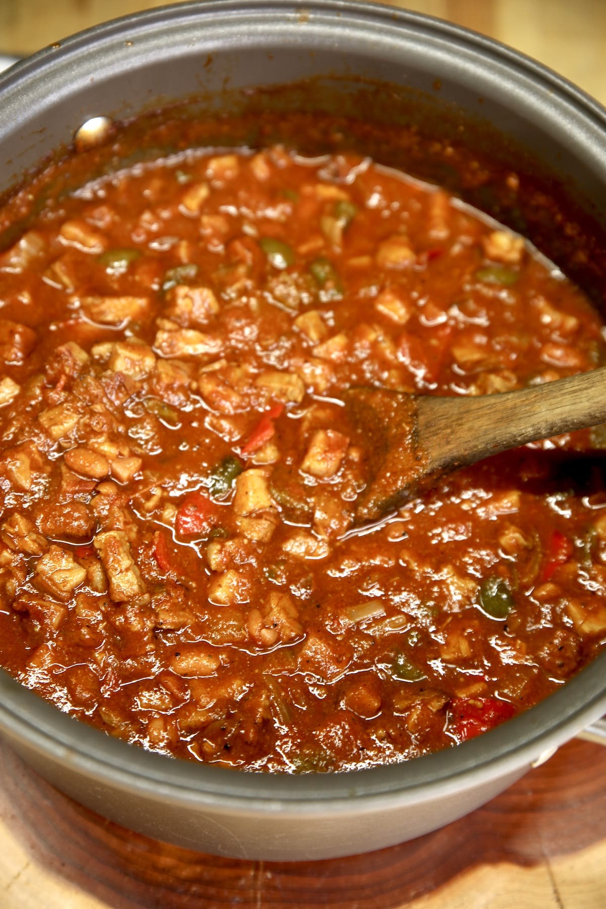 Pan of brisket chili with peppers and onions.
