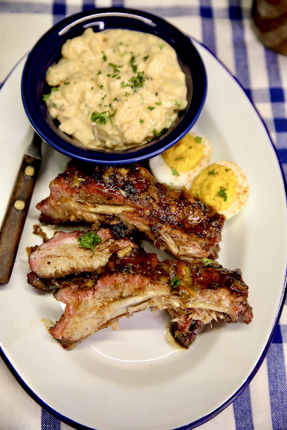 Plate with ribs, potato salad and deviled eggs.