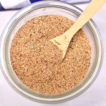 Bowl of Creole Seasoning with a wooden spoon.