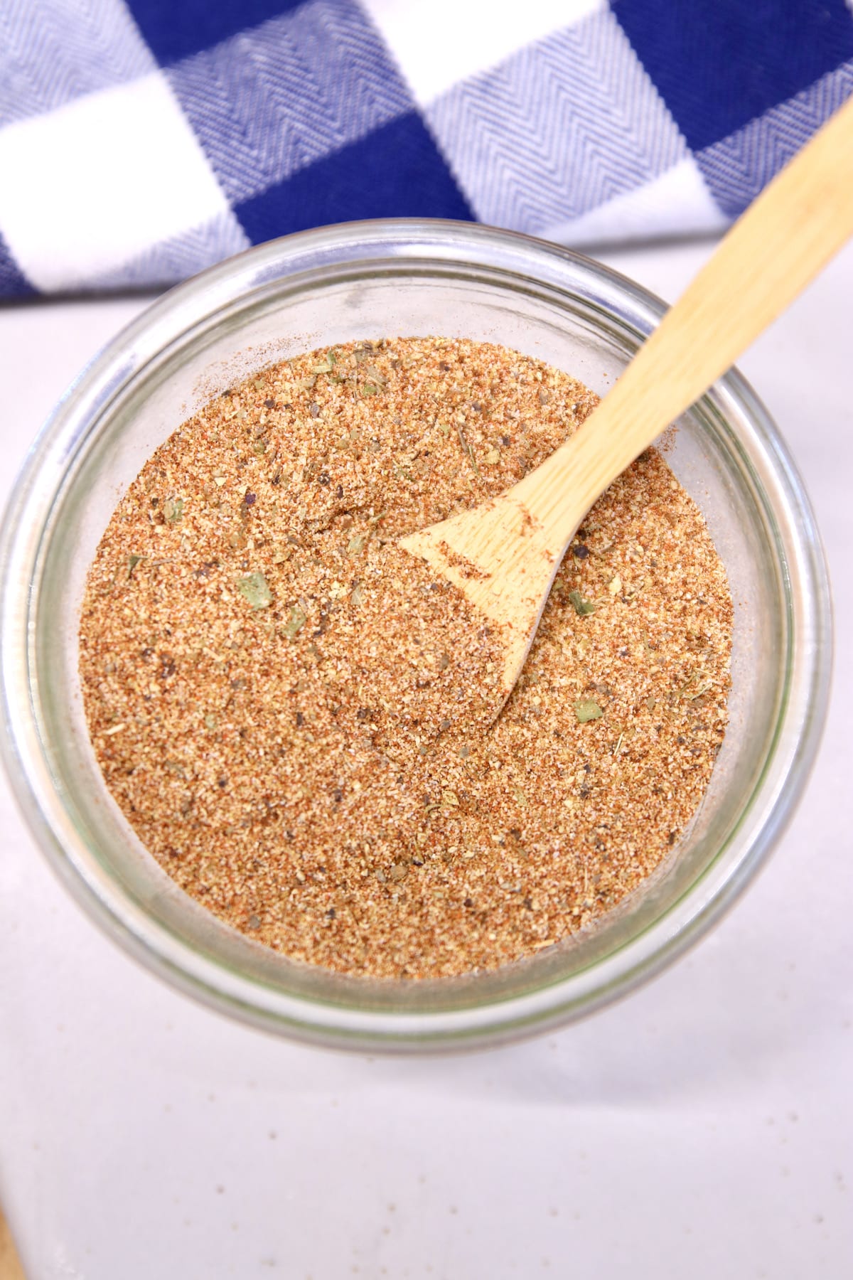 Bowl of homemade Creole seasoning with a wood spoon.