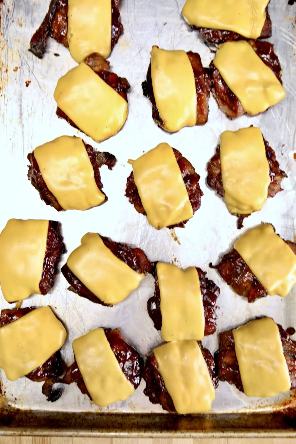 Venison cheeseburgers slider patties on a sheet pan.