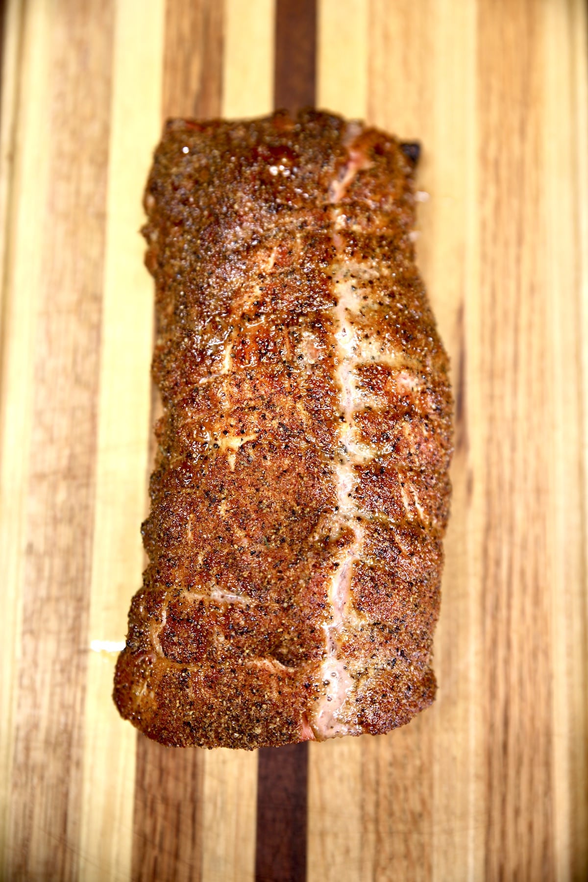 Grilled pork loin resting on a cutting board.