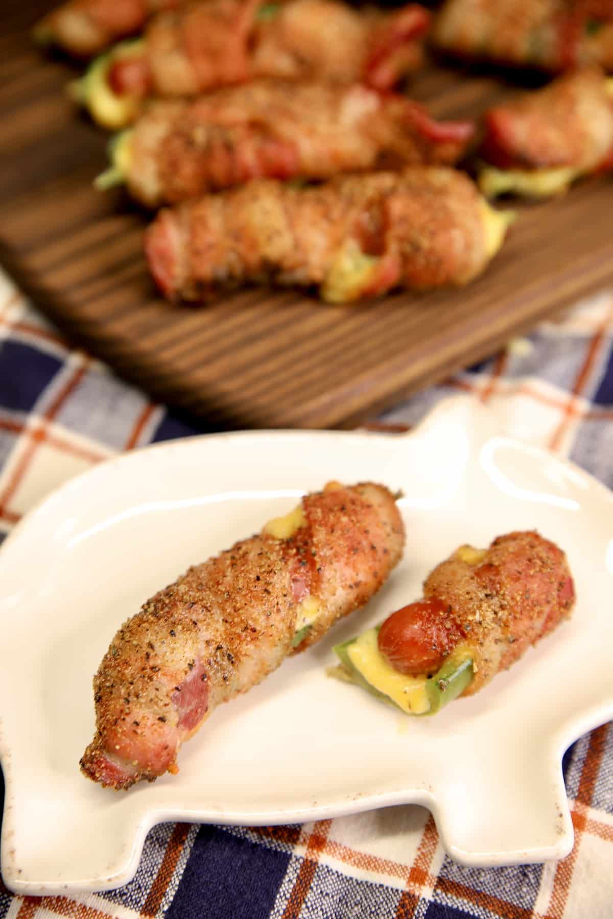 Small plate with jalapeno poppers stuffed with cheese and little smokies.