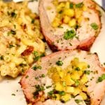 Pineapple stuffed pork loin slices on a plate with mac and cheese. Text overlay.
