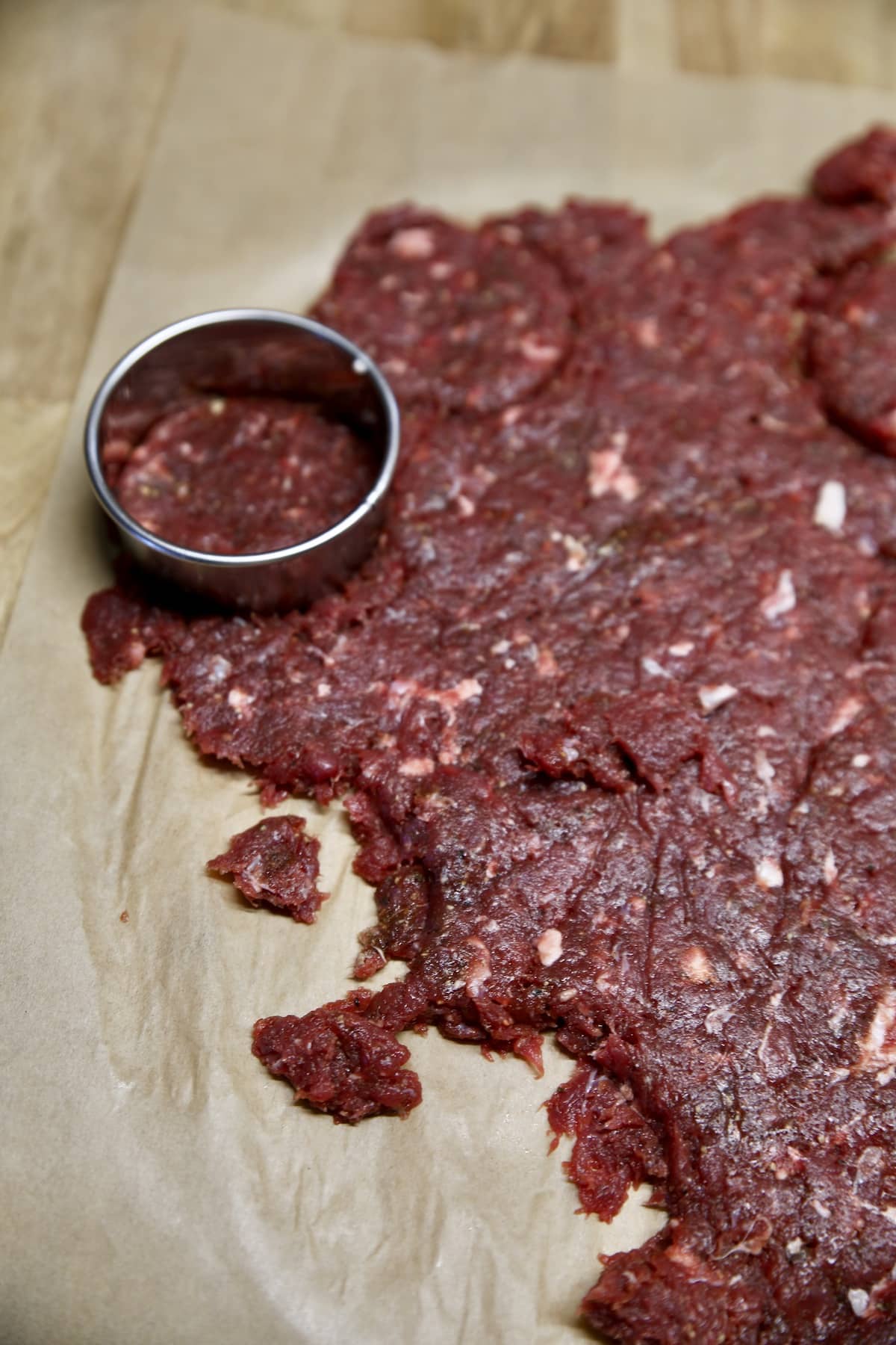 Using a biscuit cutter to cut venison slider burgers.