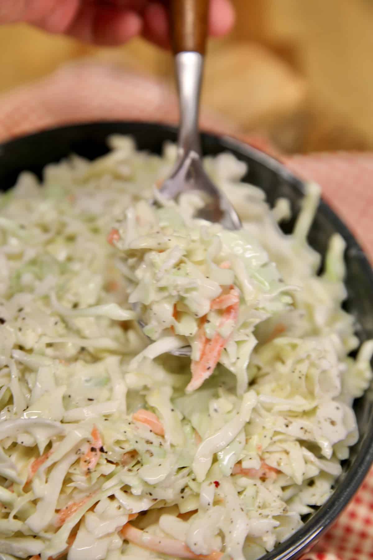 Spoonful of coleslaw in bowl.