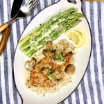 Chicken Diane with asparagus and sliced lemon.