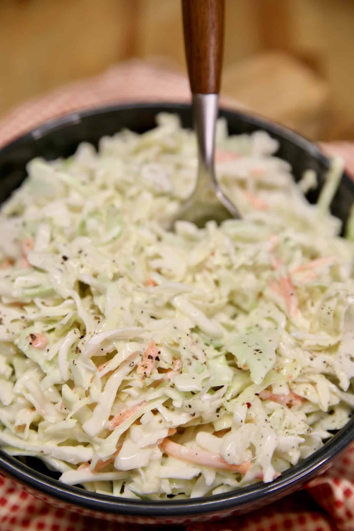 Bowl of coleslaw with spoon.