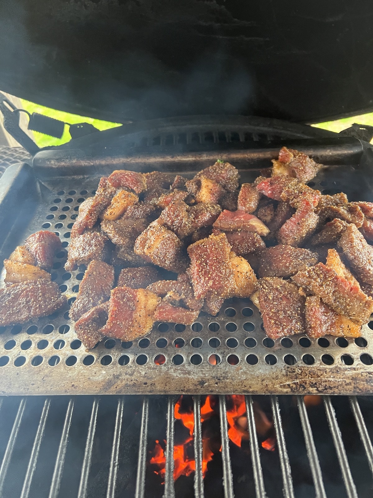 Grilling beef chunks for stew.