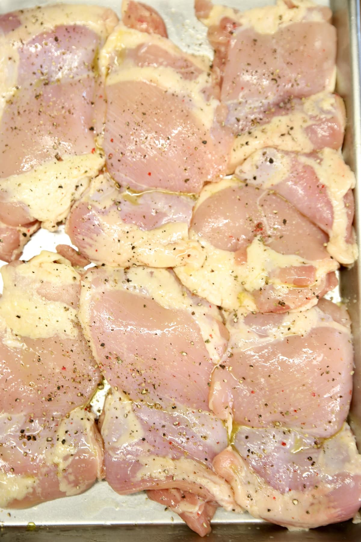 Boneless chicken thighs with olive oil, salt and pepper ready to grill.