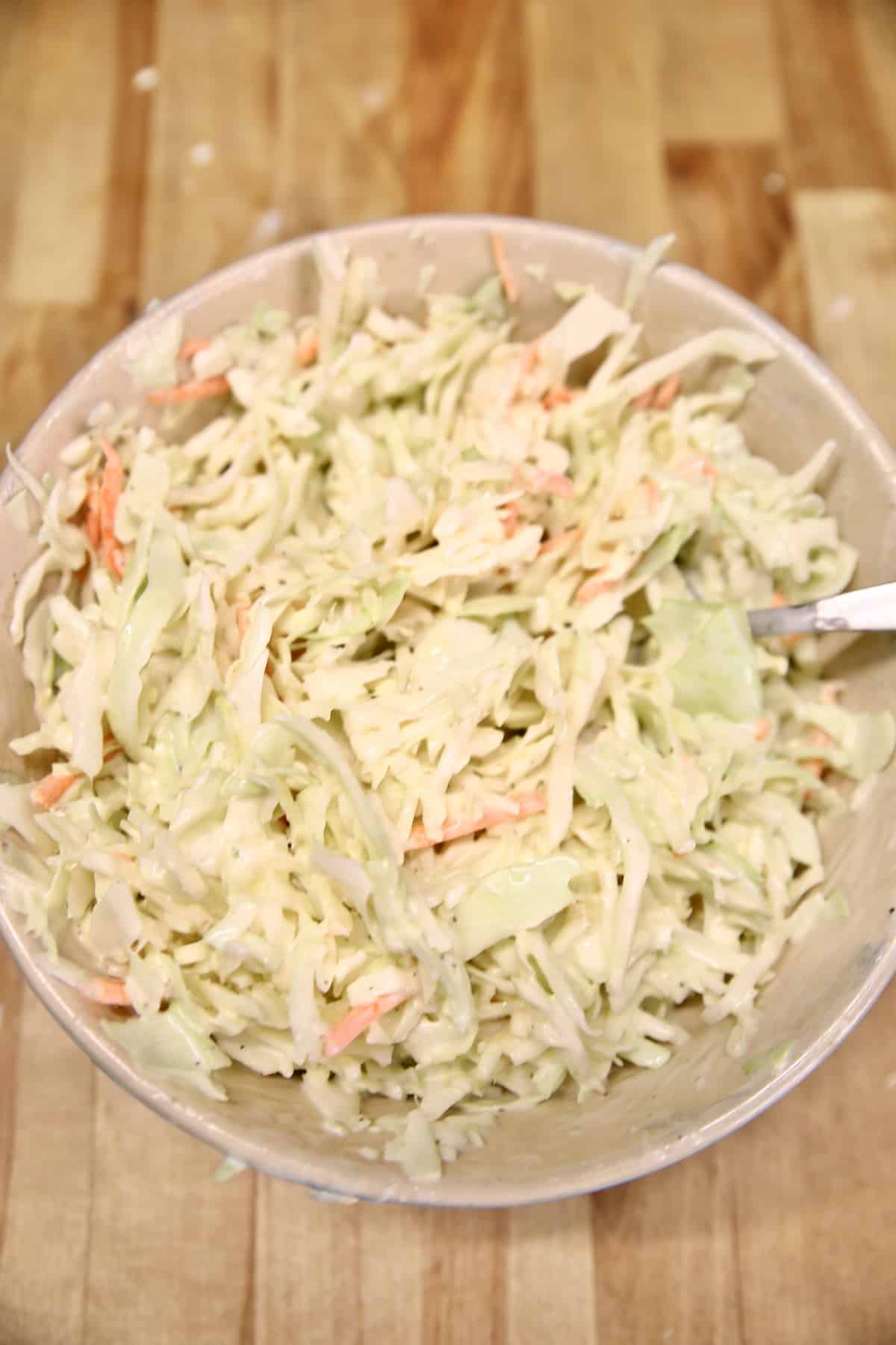 Bowl of creamy coleslaw with cabbage and carrots.