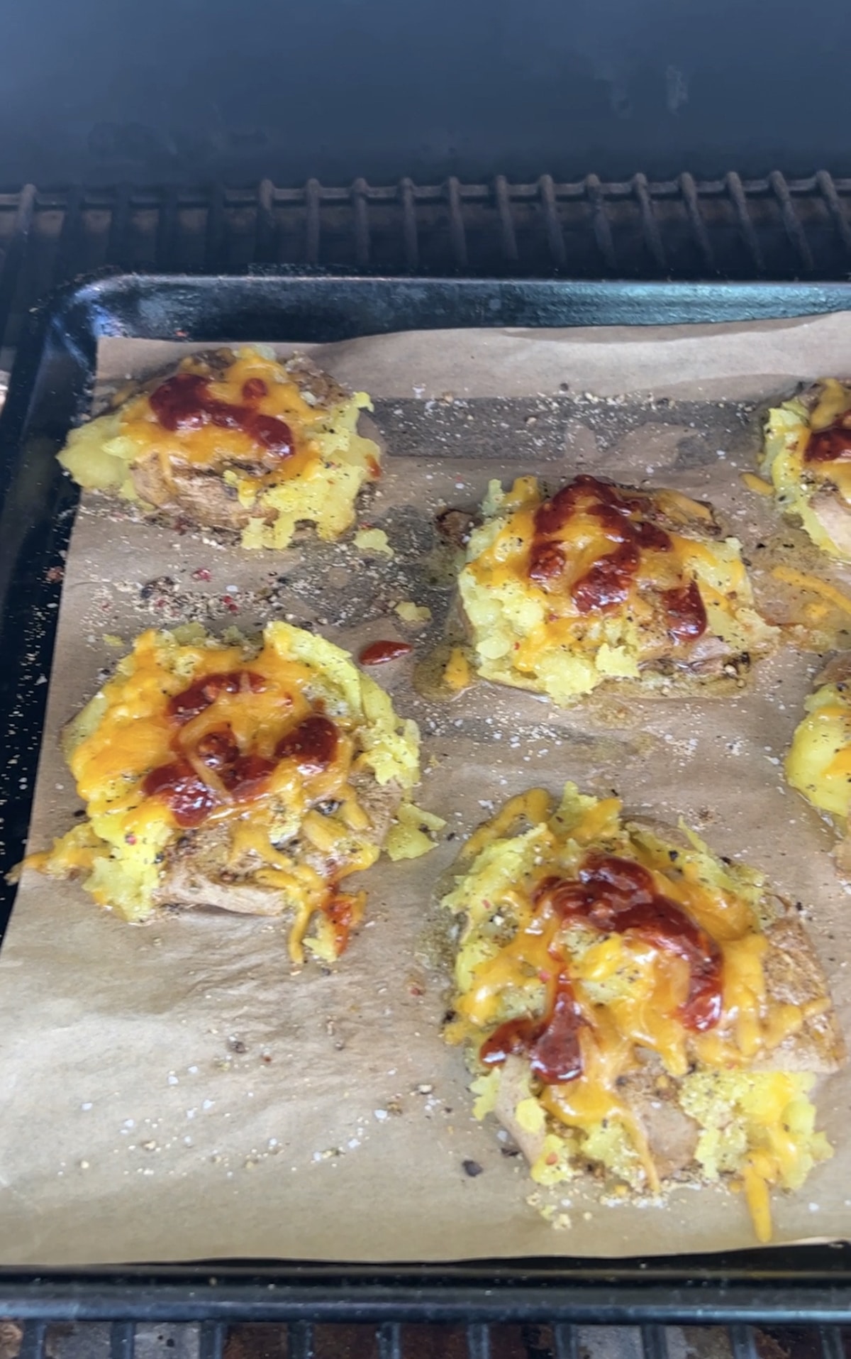 Cheesy Smashed potatoes cooking on pellet grill.