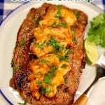 Ribeye steak topped with grilled shrimp and cilantro. Text overlay.