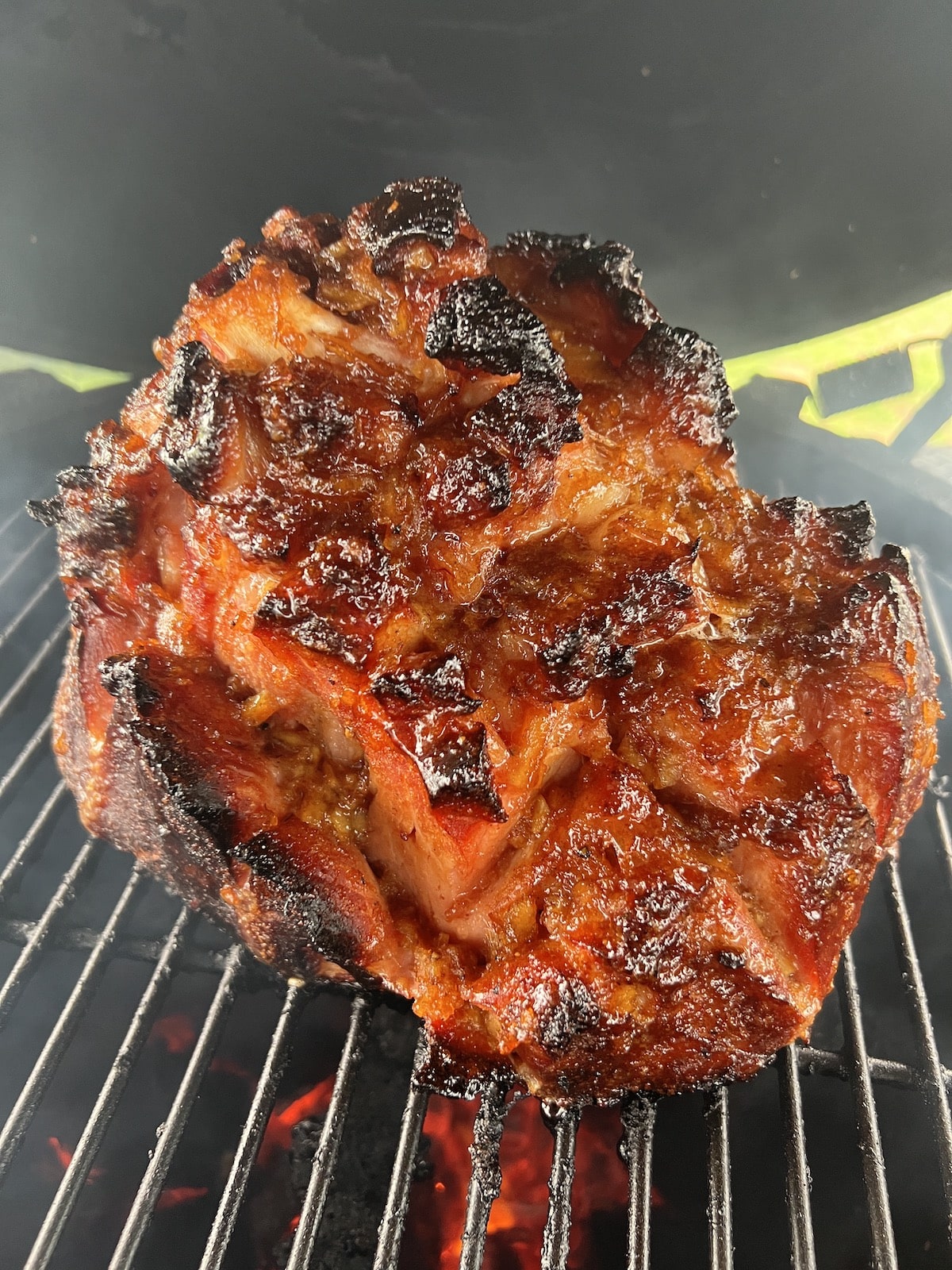 Smoked, glazed ham on a grill.