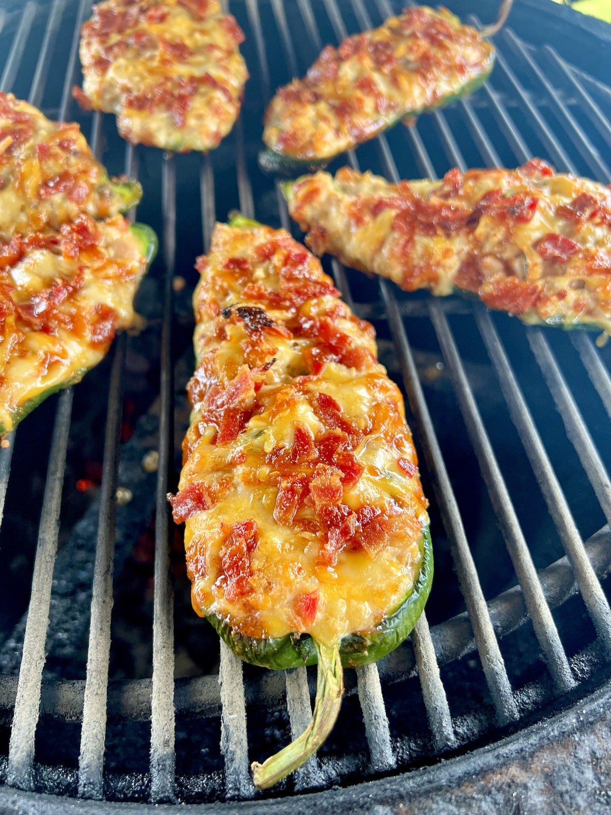 Grilling chicken stuffed poblano peppers with bacon and cheese.