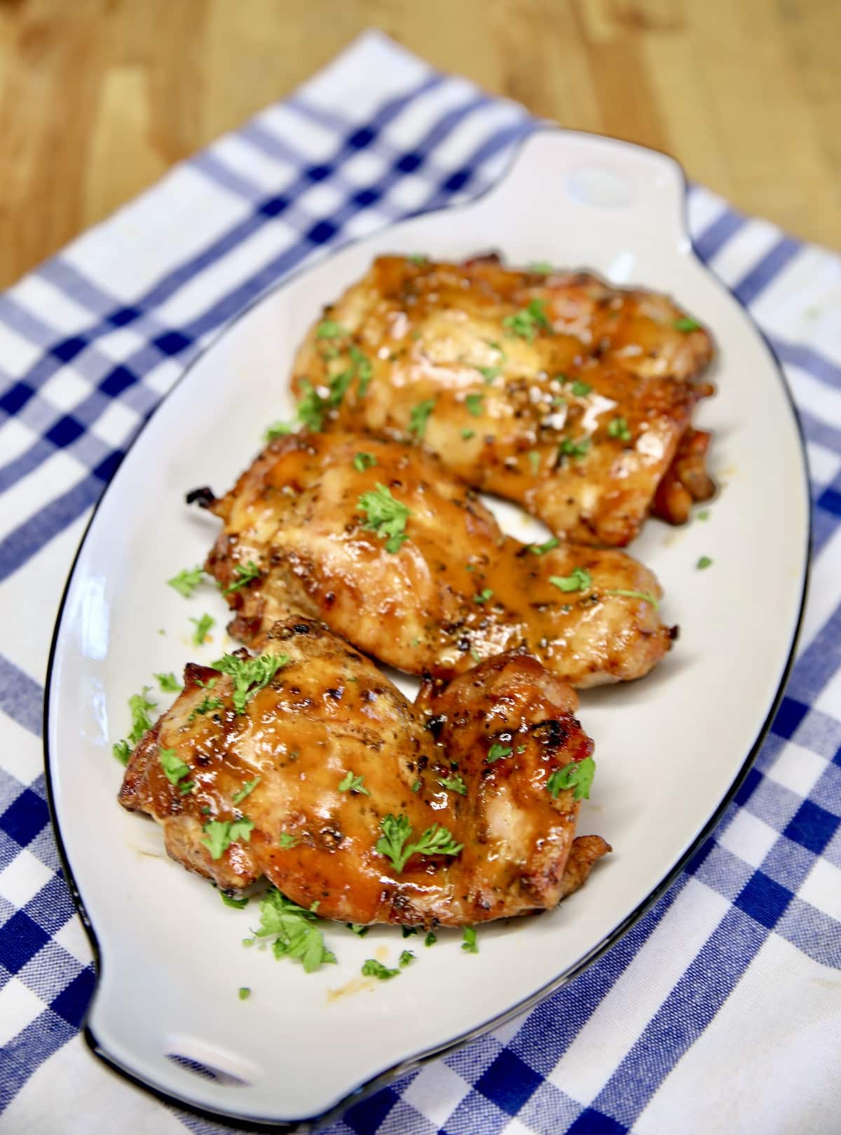 Platter of grilled chicken thighs with sweet mustard bbq sauce.