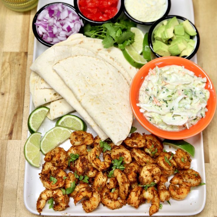 Platter with shrimp tacos and toppings- not assembled.