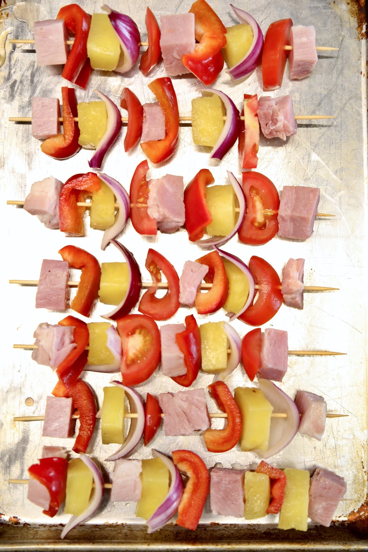 Sheet pan with pineapple and ham kabobs with veegetables.