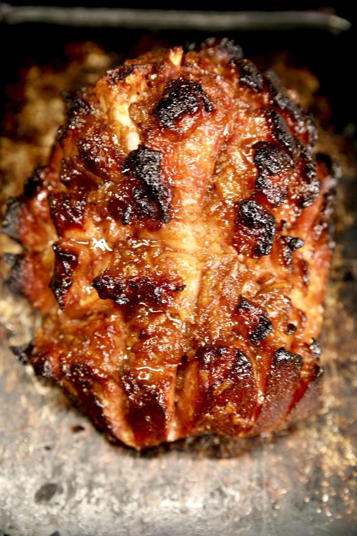 Grilled ham resting on baking sheet.