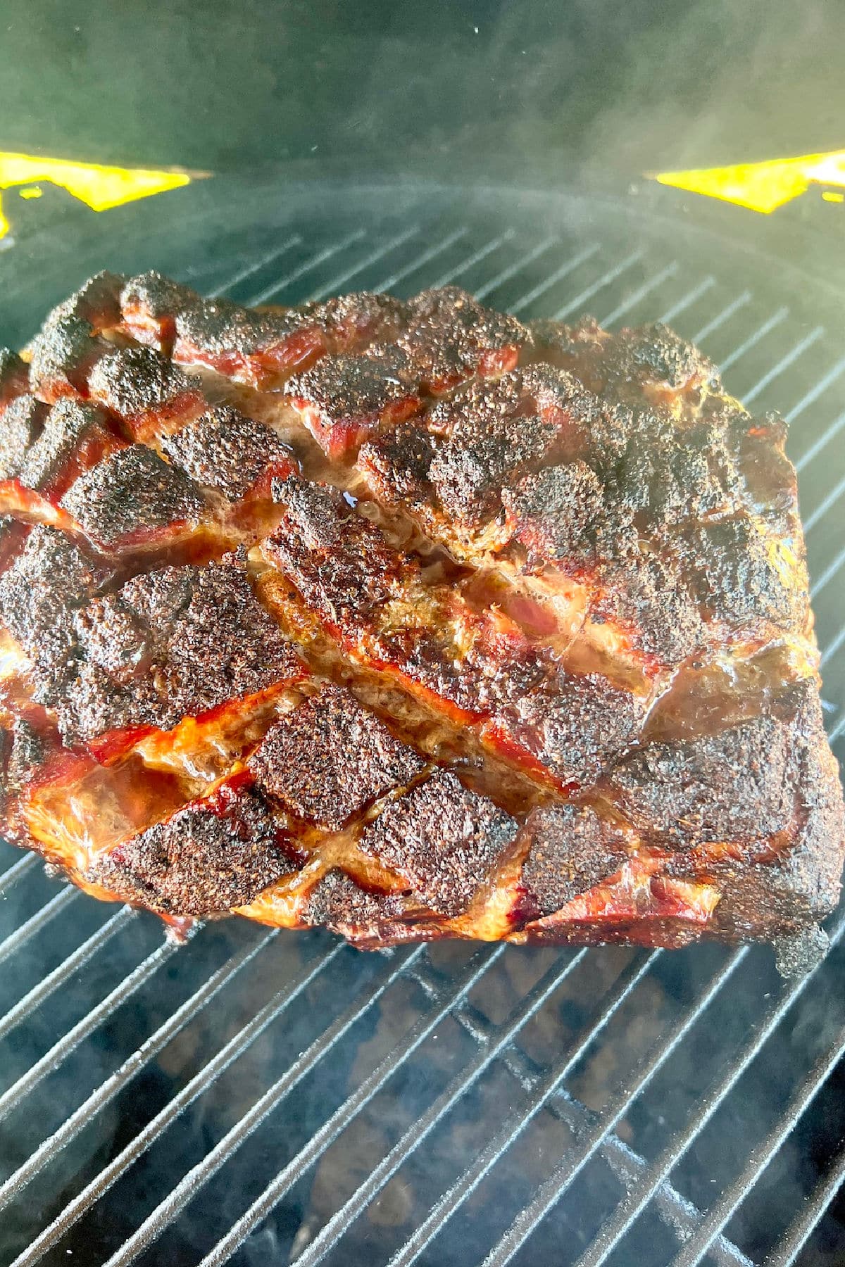 Grilling pork butt on a grill.