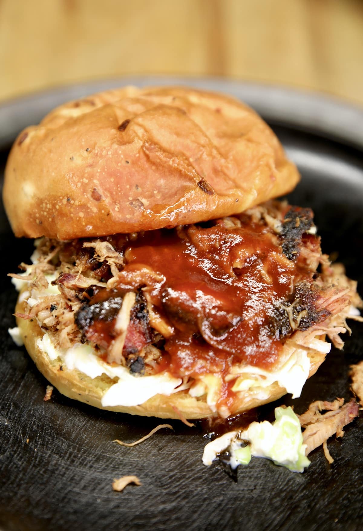 Pulled pork sandwich with coleslaw and bbq sauce.