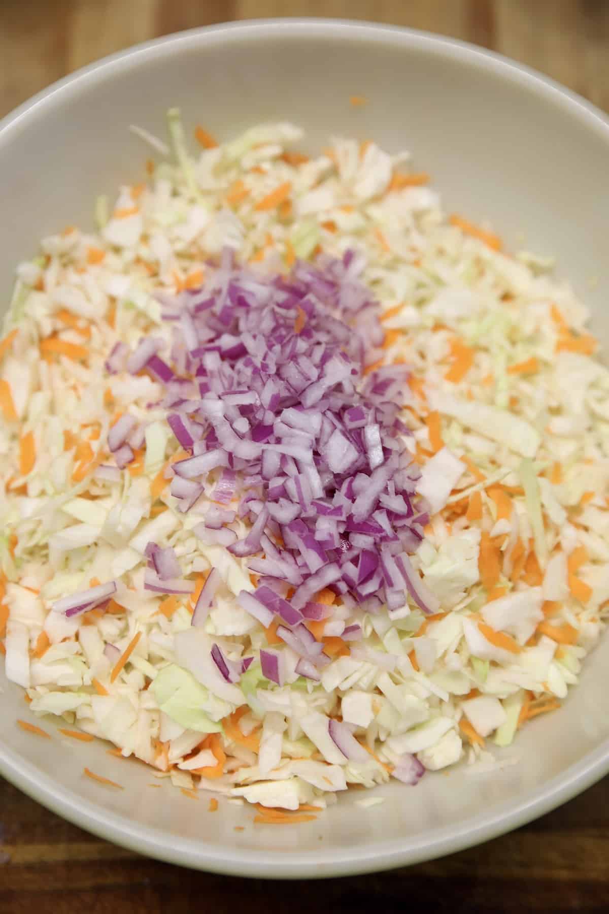 Cabbage, carrots and red onion in a bowl for slaw.