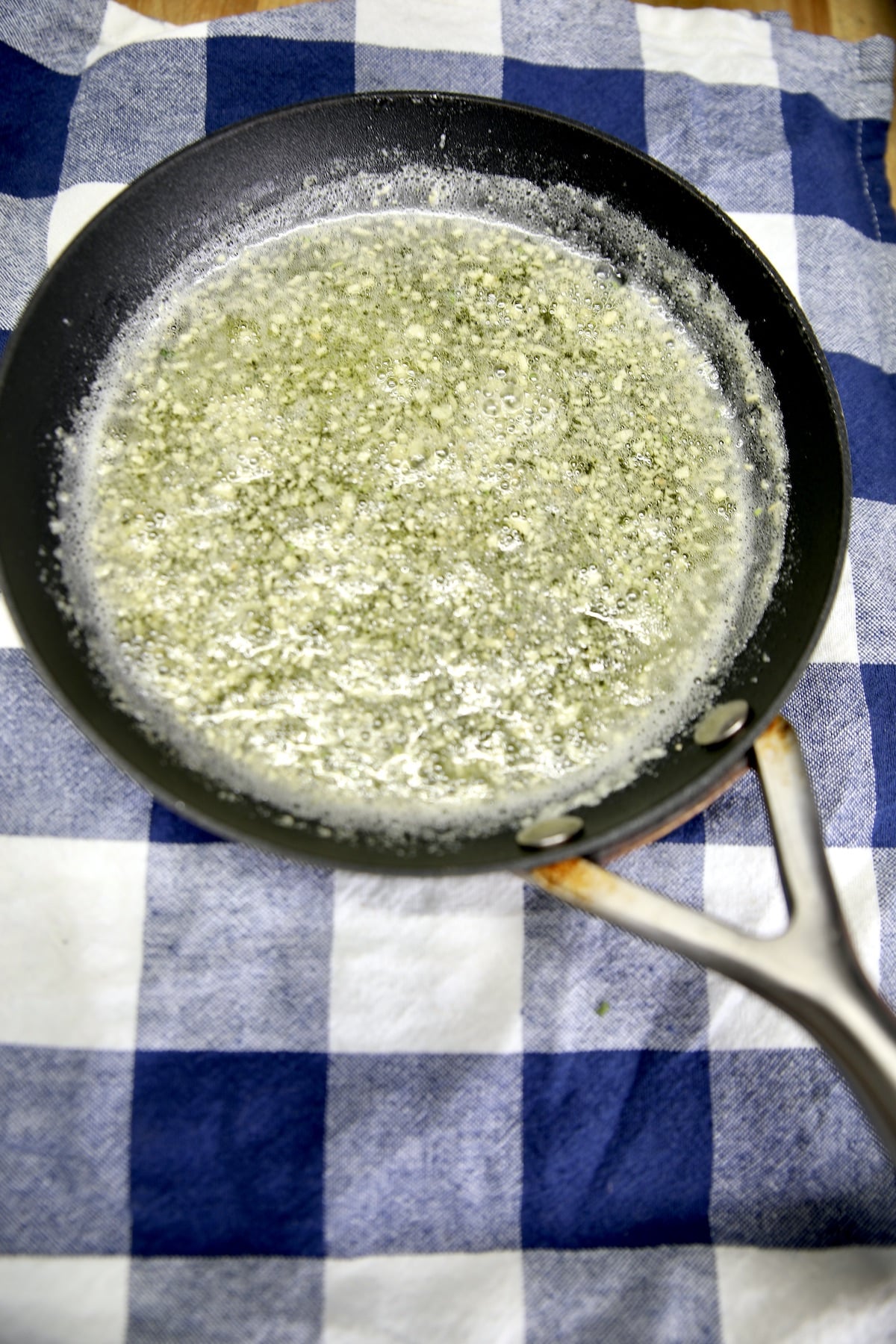 Melted butter with minced garlic in a small pan.