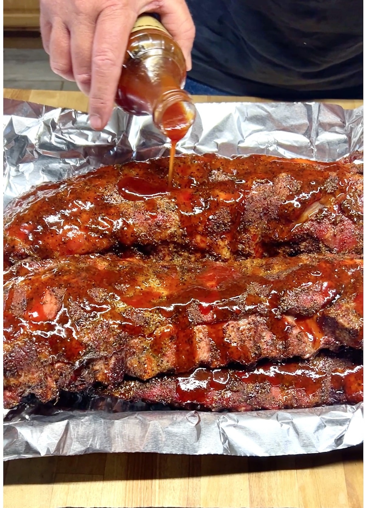 Pouring BBQ Sauce on ribs.