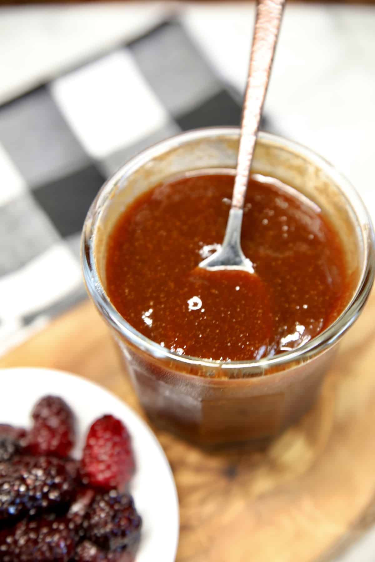 Blackberry BBQ Sauce in a jar with bowl of blackberries.