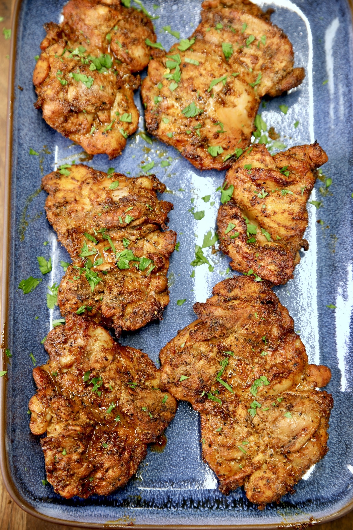 Grilled chicken thighs with shawarma marinade on a platter.