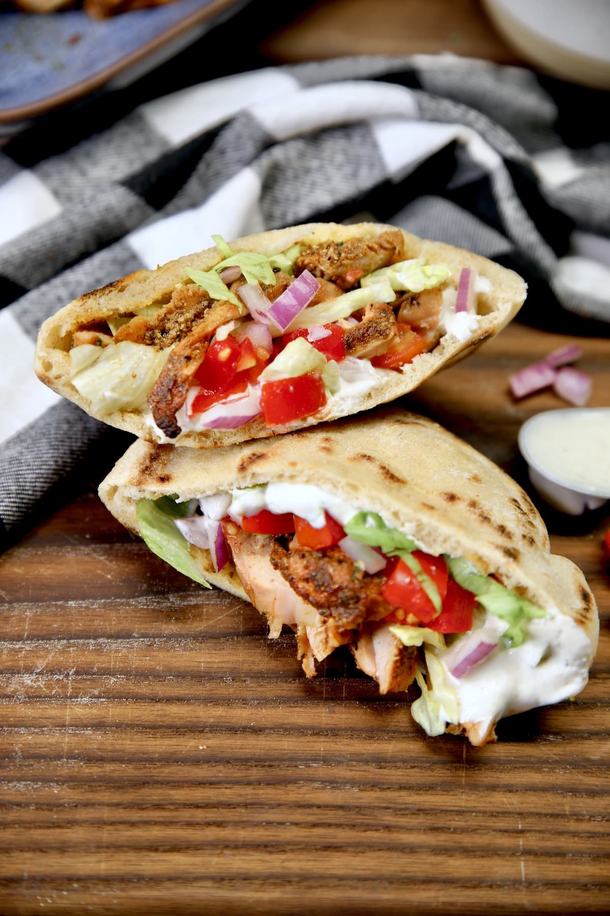 Chicken shawarma pita sandwich with tomatoes, cucumbers and red onion.