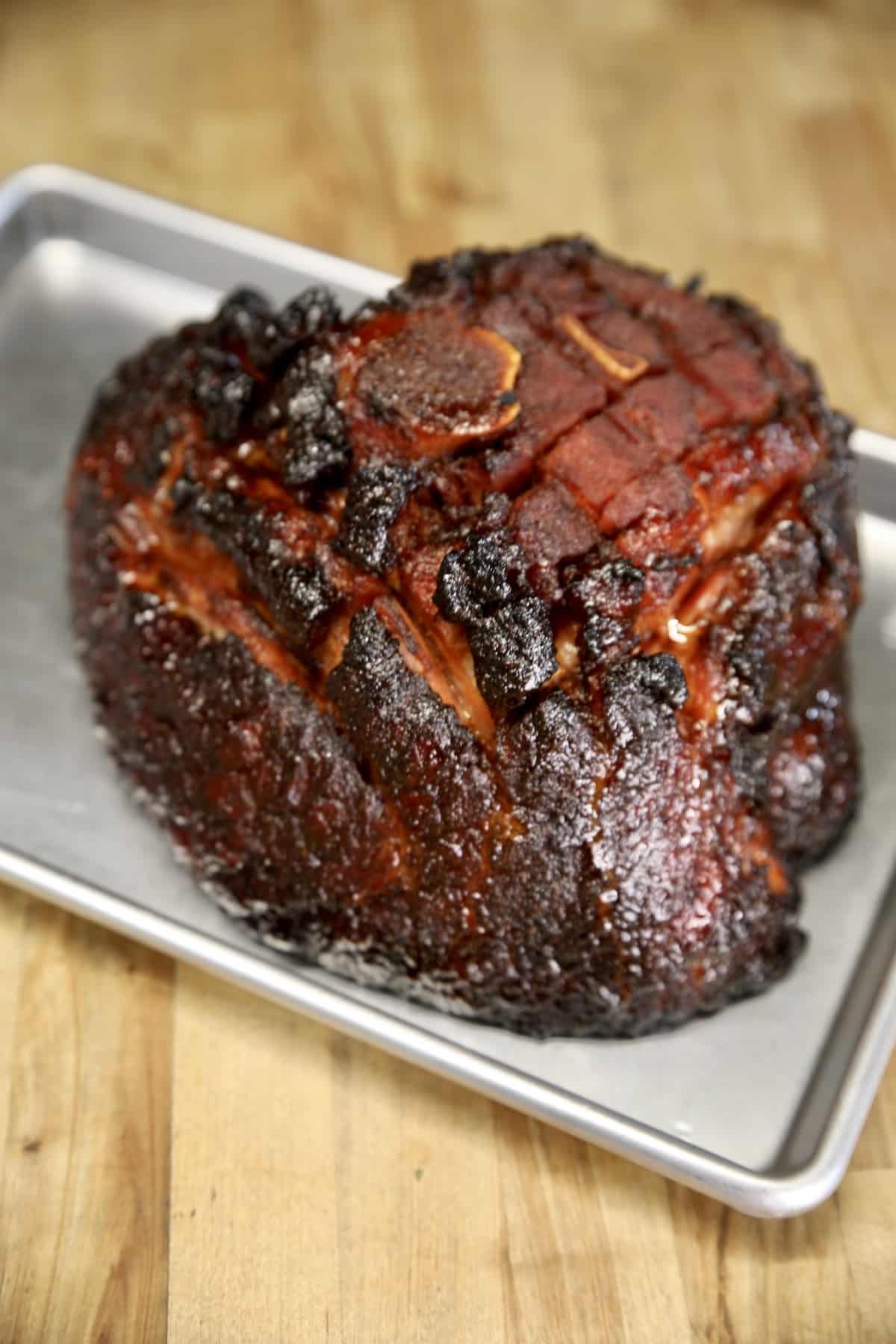 Grilled half ham on a sheet pan.