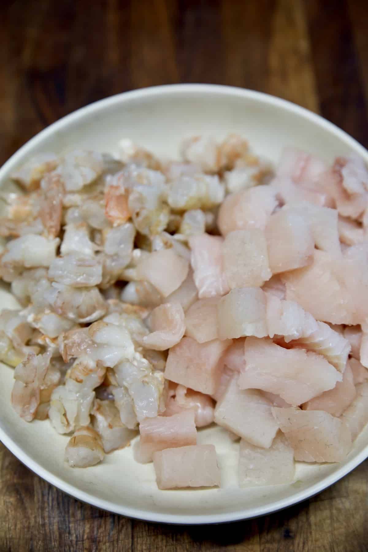 Bowl of catfish and shrimp cut into small pieces.