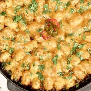 Chili cheese tater tot casserole in a cast iron skillet.