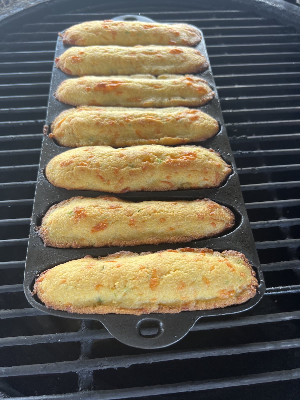 Grilling Cornbread Sticks in a cast iron pan.