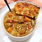 Smoked beef stew in a bowl with cornbread.