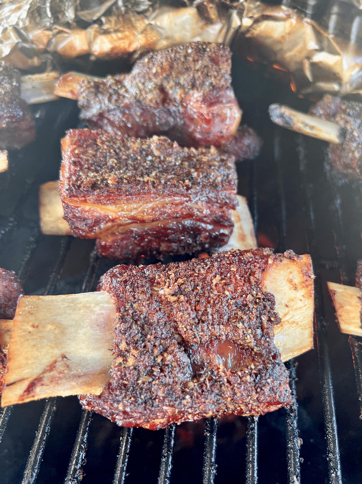Beef ribs cooking on a grill.