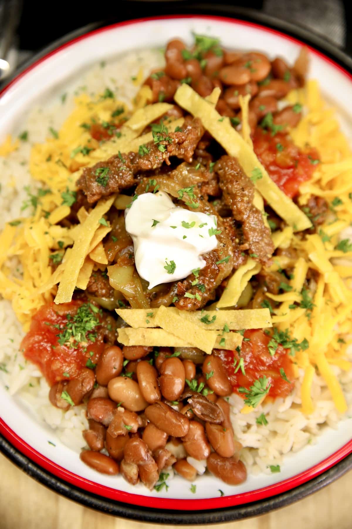 Carne asada bowls with steak, beans, rice and toppings.