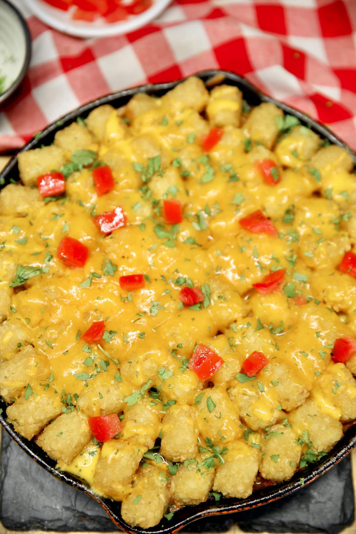Tater tot casserole with diced tomatoes and cilantro.
