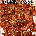 Asian beef on a platter, thin sliced with sesame seeds and cilantro.