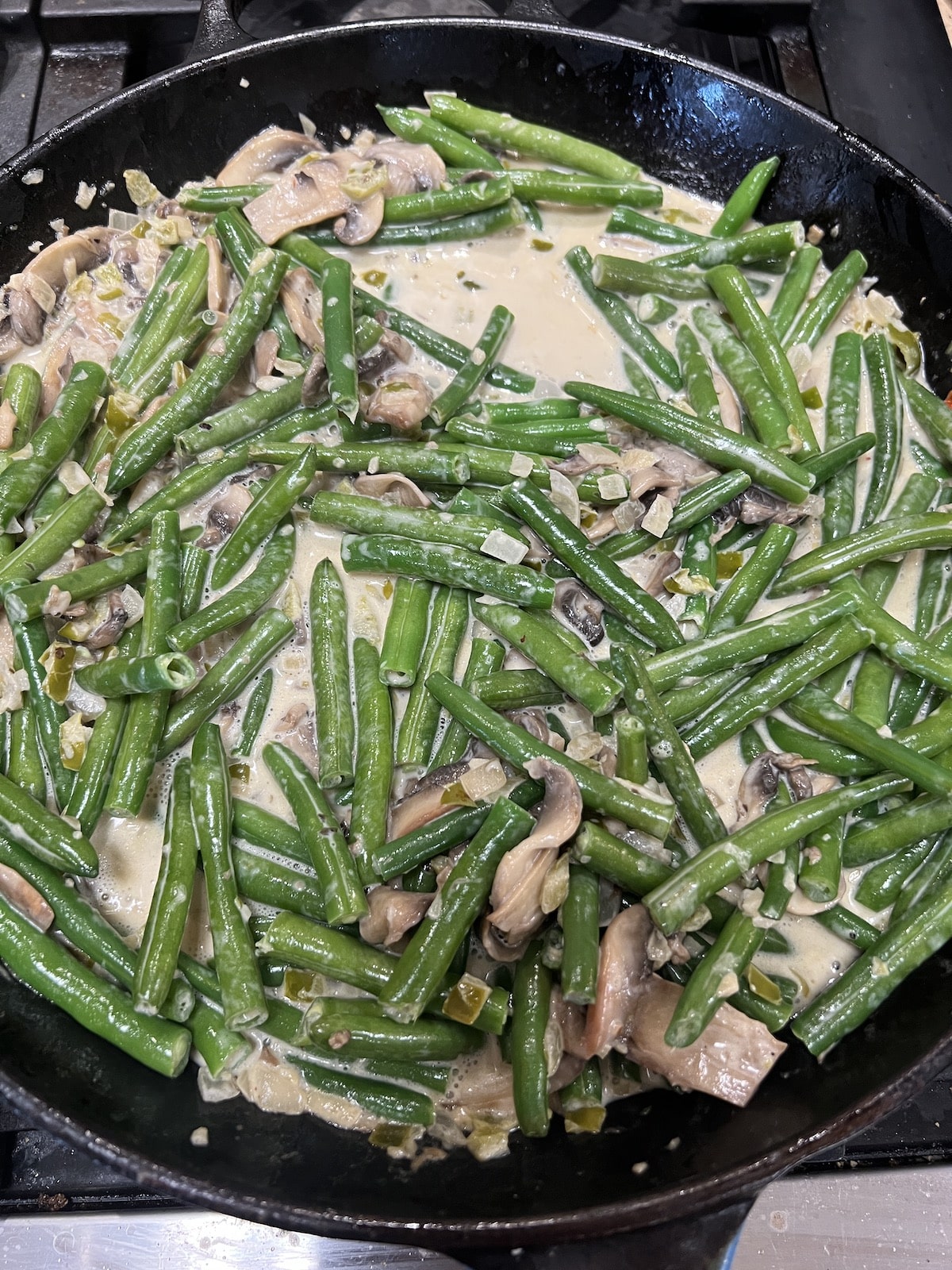 Green beans in a skillet with creamy mushroom sauce.