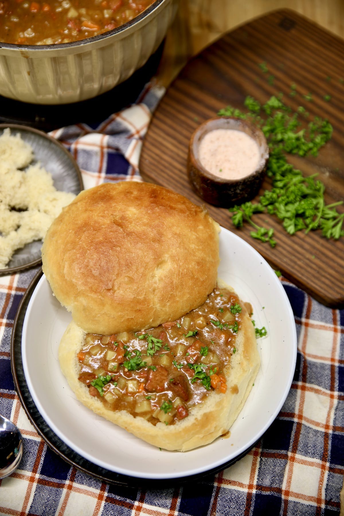 Bread bowl beef stew on a plate.
