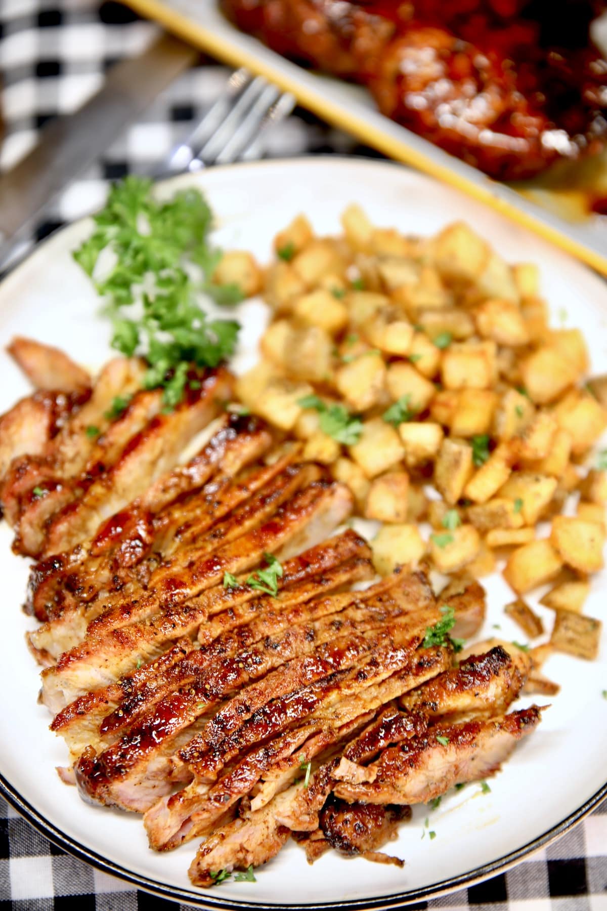 Sliced pork chop with potatoes on a plate.