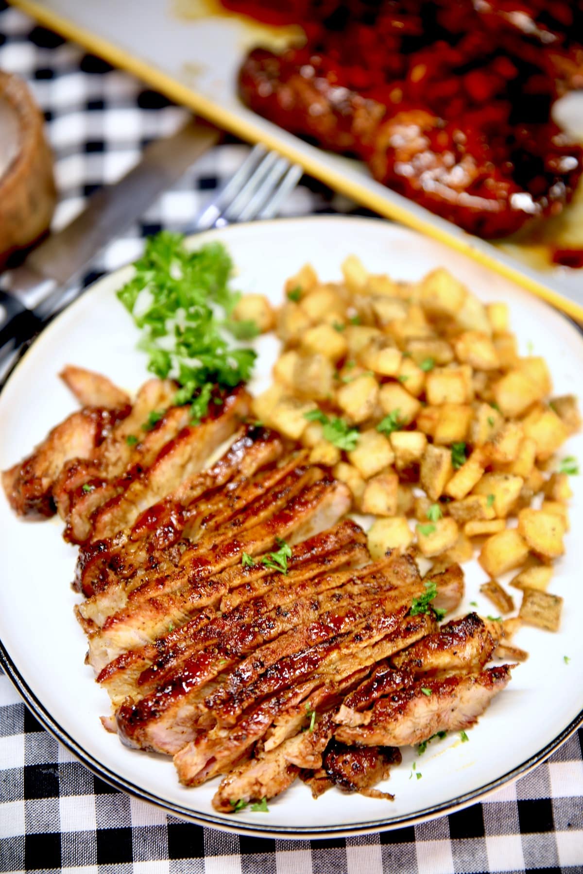 Plate with sliced pork chop, potatoes.