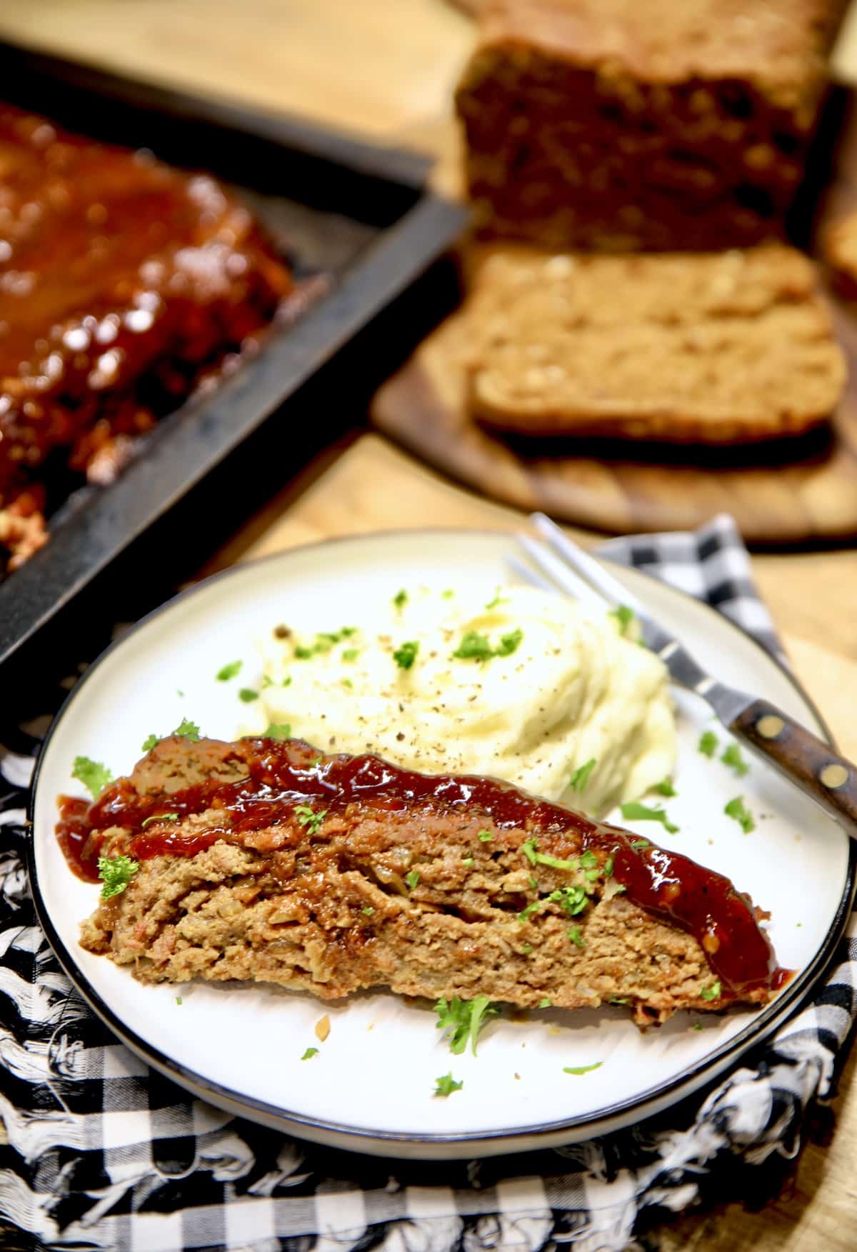 Meatloaf slices on a plate with mashed potatoes.