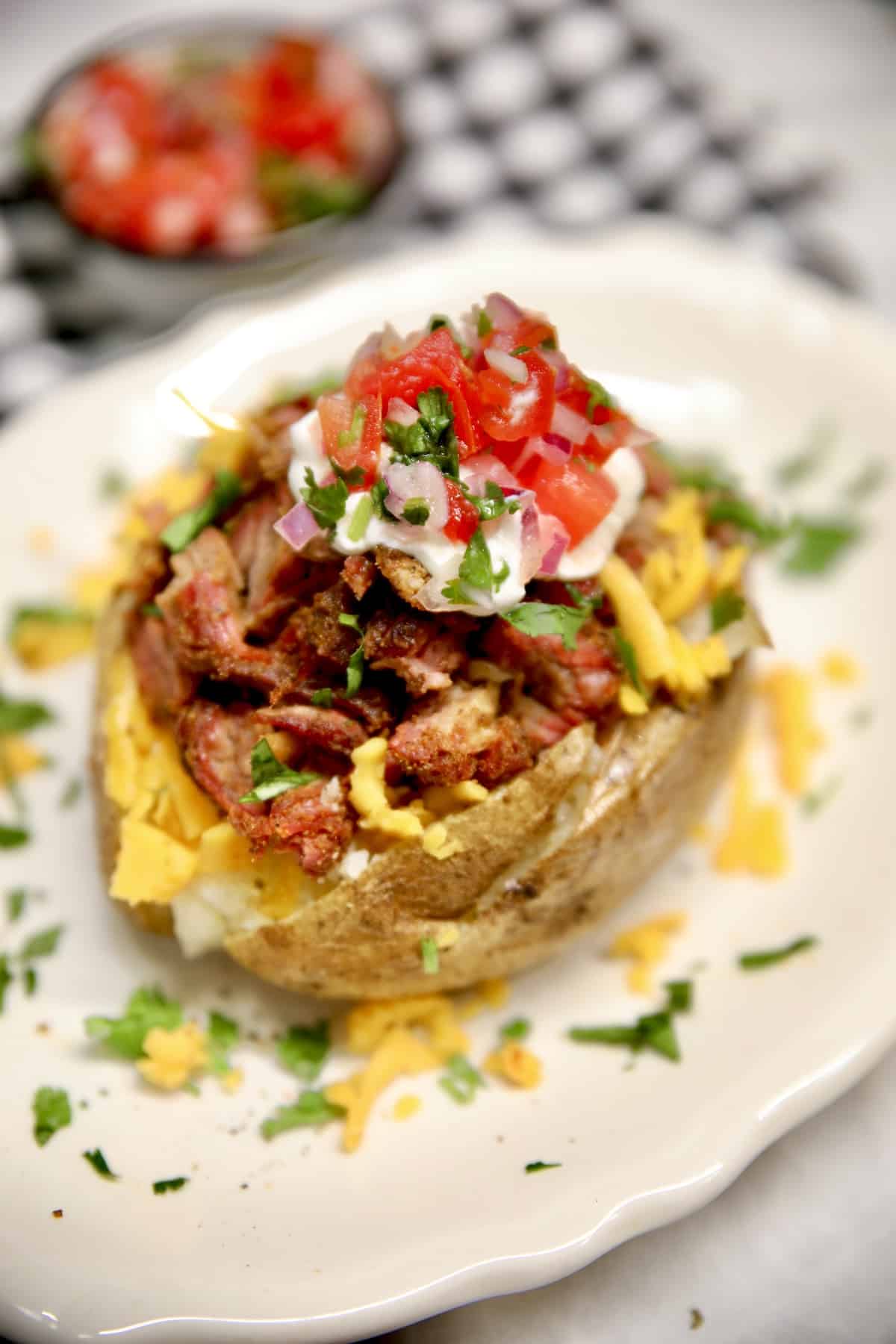 Loaded baked potato with short ribs, cheese and salsa.