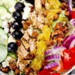 Greek salad with grilled chicken with text overlay.