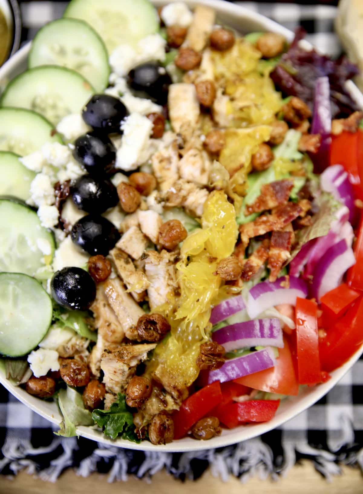 Greek salad with grilled chicken in a bowl.